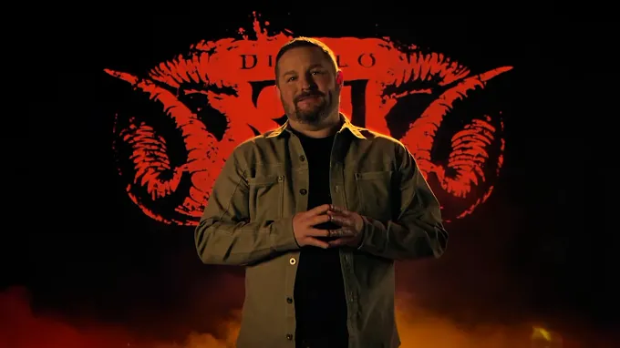 Diablo 4 Game Director Brent Gibson speaking in front of a glowing red Diablo 30th anniversary logo during the spotlight video.